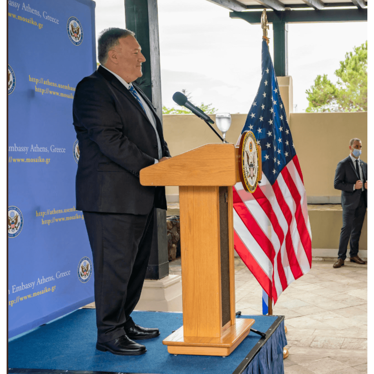 Man giving a speech behind a portable sound craft systems podium with a cup on top