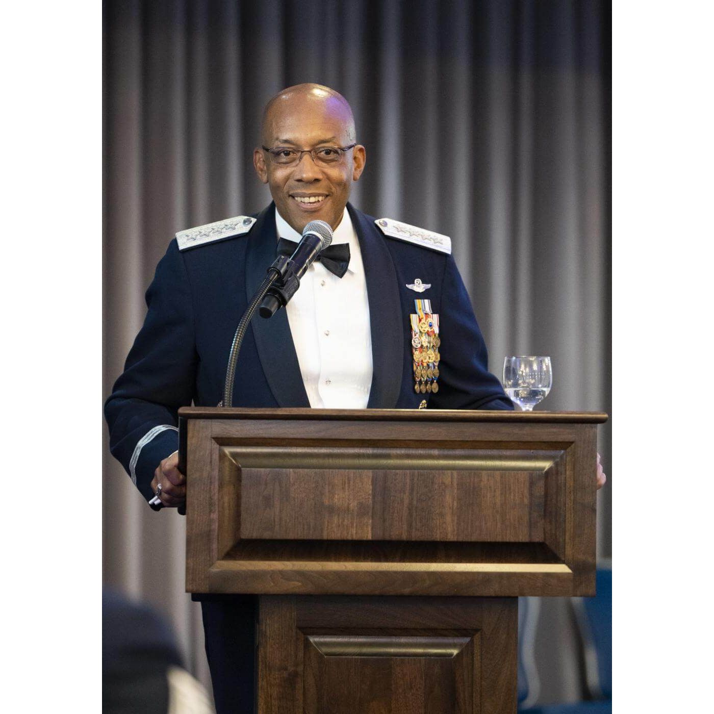 Man speaking behind a wood podium with a microphone