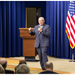 man speaking with microphone with keynote wood height adjustable podium in the background