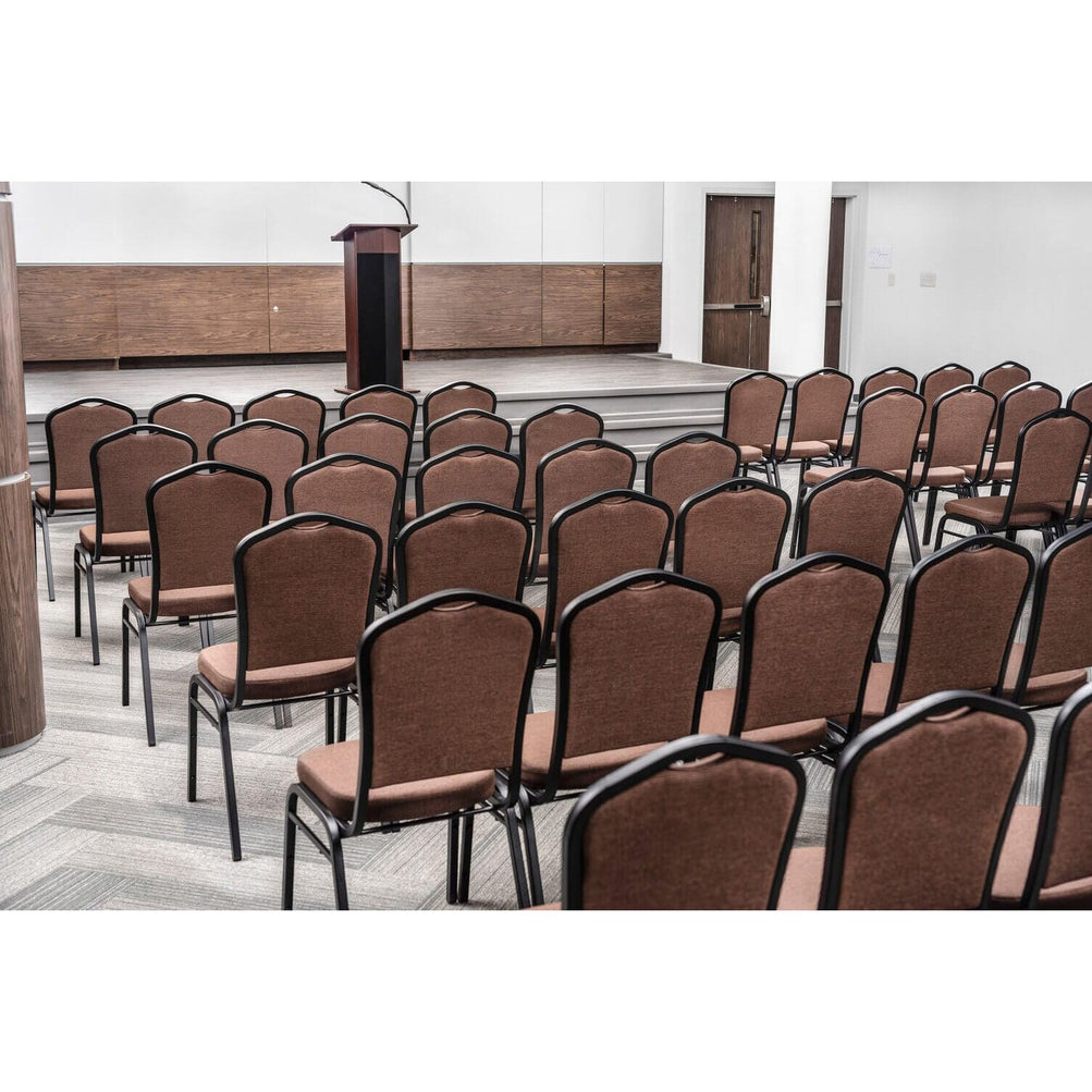 A lectern on a stage in front of a lot of chairs