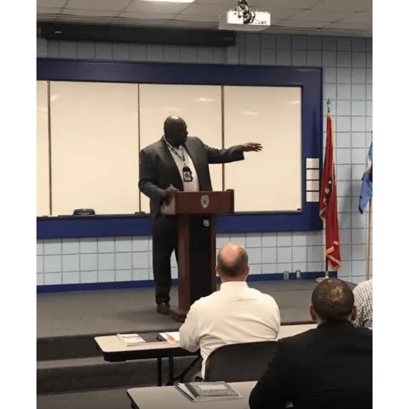 A man speaking behind a portable podium